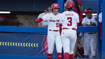May 31, 2025; Oklahoma City, OK, USA; Texas Tech Red Raiders utility Bailey Lindemuth (55) smiles and congratulates Texas Tech Red Raiders infielder Hailey Toney (32) after she stole home and scored in the fifth inning against the UCLA Bruins during the NCAA Softball Women's College World Series at Devon Park. Mandatory Credit: Brett Rojo-Imagn Images