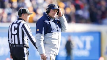 Nov 29, 2025; Morgantown, West Virginia, USA; West Virginia Mountaineers head coach Rich Rodriguez walks off the field after questioning a call with a referee during the first quarter against the Texas Tech Red Raiders at Milan Puskar Stadium. Mandatory Credit: Ben Queen-Imagn Images