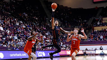 Jan 4, 2025; Blacksburg, Virginia, USA; Miami Hurricanes guard Jalil Bethea (3) shoots the ball against Virginia Tech Hokies guard Jaden Schutt (2) and forward Tobi Lawal (1) during the second half at Cassell Coliseum. Mandatory Credit: Peter Casey-Imagn Images