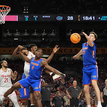 Florida Gators center Rueben Chinyelu (9) and Florida Gators forward Alex Condon (21) reach for a rebound against the Houston Cougars in the second half in the national championship game.