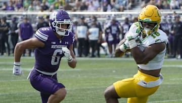 Sep 13, 2025; Evanston, Illinois, USA; Oregon Ducks tight end Kenyon Sadiq (18) catches a touchdown pass as Northwestern Wildcats defensive back Robert Fitzgerald (6) defends him during the first half at Northwestern Medicine Field at Martin Stadium. Mandatory Credit: David Banks-Imagn Images