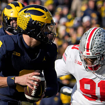 Nov. 25, 2023; Ann Arbor, Mi., USA;
Michigan Wolverines quarterback J.J. McCarthy (9) is pursued by Ohio State Buckeyes defensive tackle Tyleik Williams (91) during the first half of Saturday's NCAA Division I football game at Michigan Stadium.