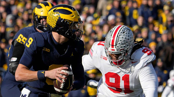 Nov. 25, 2023; Ann Arbor, Mi., USA;
Michigan Wolverines quarterback J.J. McCarthy (9) is pursued by Ohio State Buckeyes defensive tackle Tyleik Williams (91) during the first half of Saturday's NCAA Division I football game at Michigan Stadium.