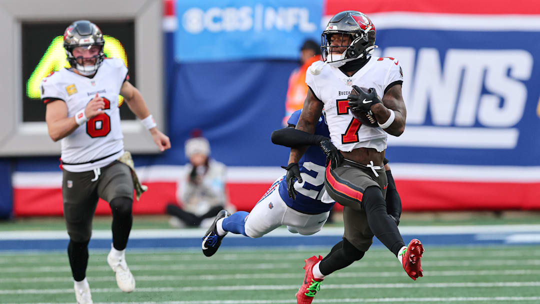 Nov 24, 2024; East Rutherford, New Jersey, USA; Tampa Bay Buccaneers running back Bucky Irving (7) fights for yards as New York Giants cornerback Dru Phillips (22) tackles during the first half at MetLife Stadium. Mandatory Credit: Vincent Carchietta-Imagn Images