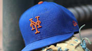Jul 13, 2022; Atlanta, Georgia, USA; A detailed view of a New York Mets hat and glove in the dugout against the Atlanta Braves in the eighth inning at Truist Park. 