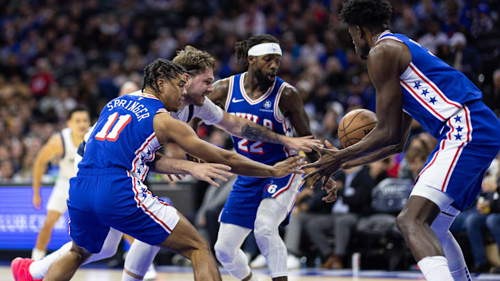 Feb 5, 2024; Philadelphia, Pennsylvania, USA; Dallas Mavericks guard Luka Doncic (77) and Philadelphia 76ers guard Jaden Springer (11) and guard Patrick Beverley (22) chase a loose ball during the second quarter at Wells Fargo Center. Mandatory Credit: Bill Streicher-Imagn Images