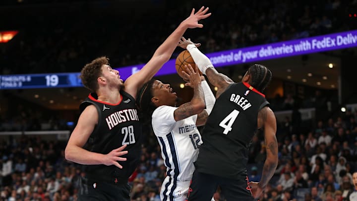 Jan 9, 2025; Memphis, Tennessee, USA; Memphis Grizzlies guard Ja Morant (12) drives to the basket as Houston Rockets center Alperen Sengun (28) and guard Jalen Green (4) defend during the first quarter at FedExForum. Mandatory Credit: Petre Thomas-Imagn Images