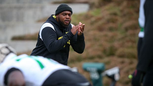 Oregon offensive line coach A'lique Terry leads a workout during spring practice with the Ducks in Eugene, Ore. Thursday, Apr
