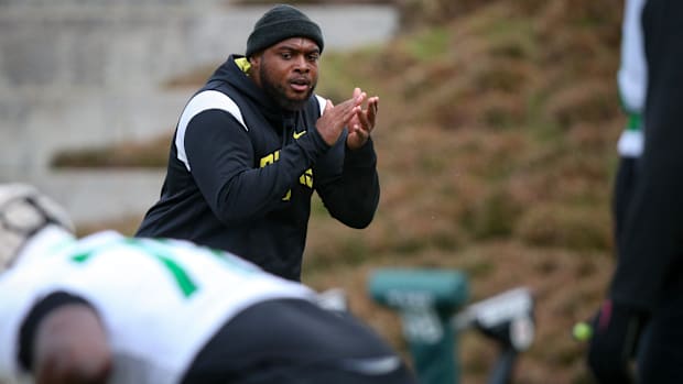 Oregon offensive line coach A'lique Terry leads a workout during spring practice with the Ducks in Eugene, Ore. Thursday, Apr