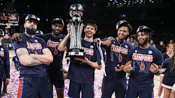 The Duquesne Dukes celebrate after winning the Atlantic 10