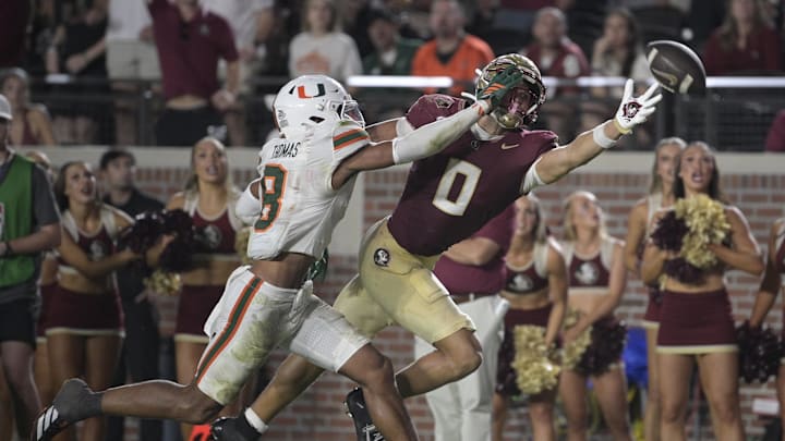 Oct 4, 2025; Tallahassee, Florida, USA; Florida State Seminoles wide receiver Duce Robinson reaches for a pass against Miami Hurricanes defensive back Jakobe Thomas (8) during the second half at Doak S. Campbell Stadium. Mandatory Credit: Melina Myers-Imagn Images