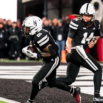 Nov 1, 2025; Lincoln, Nebraska, USA; Nebraska Cornhuskers quarterback TJ Lateef (14) hands the ball off to running back Emmett Johnson (21) against the Southern California Trojans during the fourth quarter at Memorial Stadium. 