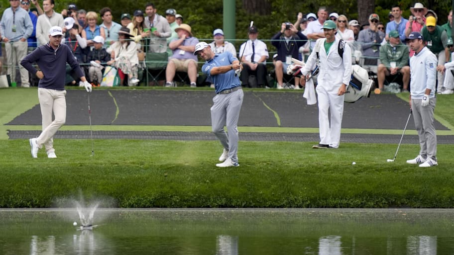 Ryan Gerard and Nick Taylor watch as Corey Conners skips a ball on the 16th hole during a Masters practice round.