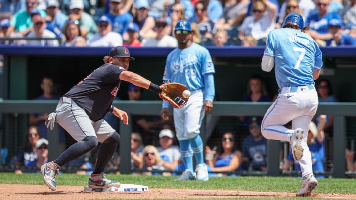 Jun 30, 2024; Kansas City, Missouri, USA; Cleveland Guardians first base Josh Naylor (22) reaches for a throw around Kansas City Royals shortstop Bobby Witt Jr. (7) at first base during the seventh inning at Kauffman Stadium. Mandatory Credit: William Purnell-USA TODAY Sports