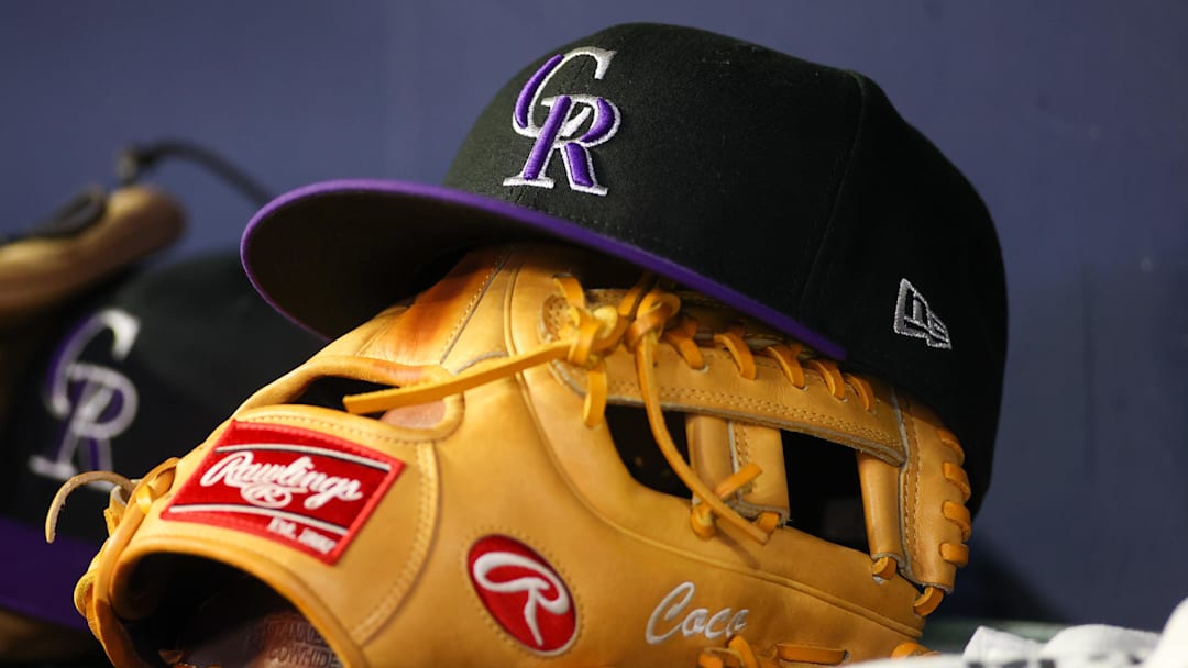 Jun 15, 2023; Atlanta, Georgia, USA; A detailed view of a Colorado Rockies hat and glove on the bench against the Atlanta Braves in the ninth inning at Truist Park. 