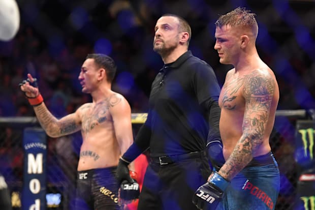 Dustin Poirier (blue gloves) reacts after a bout against Max Holloway (red gloves) during UFC 236 at State Farm Arena.