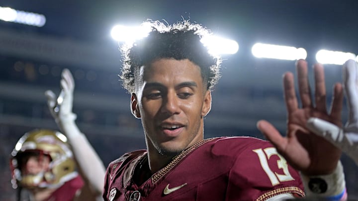 Nov 11, 2023; Tallahassee, Florida, USA; Florida State Seminoles quarterback Jordan Travis (13) high fives a young fan after winning the game against the Miami Hurricanes at Doak S. Campbell Stadium. Mandatory Credit: Melina Myers-Imagn Images