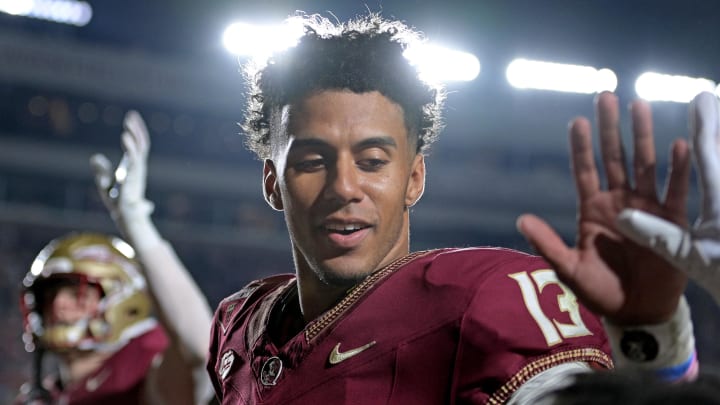 Nov 11, 2023; Tallahassee, Florida, USA; Florida State Seminoles quarterback Jordan Travis (13) high fives a young fan after winning the game against the Miami Hurricanes at Doak S. Campbell Stadium. Mandatory Credit: Melina Myers-USA TODAY Sports