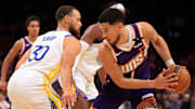 Apr 8, 2025; Phoenix, Arizona, USA; Phoenix Suns guard Devin Booker (1) attempts to drive to the basket against Golden State Warriors guard Stephen Curry (30) during the second half at Footprint Center. Mandatory Credit: Mark J. Rebilas-Imagn Images