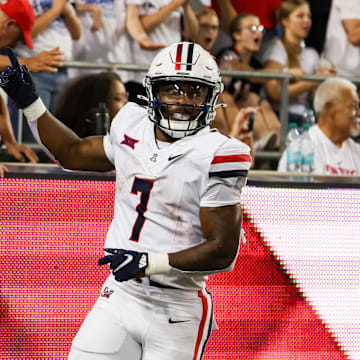 Aug 31, 2024; Tucson, Arizona, USA; Arizona Wildcats running back Quali Conley (7) celebrates touchdown with Arizona Wildcat fans during fourth quarter at Arizona Stadium. 