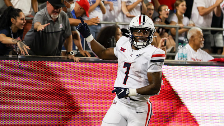 Aug 31, 2024; Tucson, Arizona, USA; Arizona Wildcats running back Quali Conley (7) celebrates touchdown with Arizona Wildcat fans during fourth quarter at Arizona Stadium. 