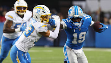 Jul 31, 2025; Canton, Ohio, USA;  Detroit Lions wide receiver Dominic Lovett (19) runs after a catch as Los Angeles Chargers cornerback Deane Leonard (33) defends during the first half at Tom Benson Hall of Fame Stadium. Mandatory Credit: Charles LeClaire-Imagn Images