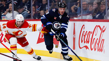 Sep 27, 2025; Winnipeg, Manitoba, CAN;  Winnipeg Jets forward Jonathan Toews (19) tries to skates away from Calgary Flames defenseman Joel Hamley (44) during the second period at Canada Life Centre. Mandatory Credit: Terrence Lee-Imagn Images
