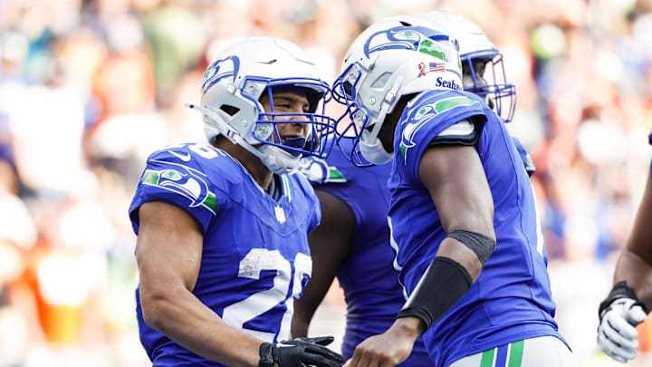 Sep 8, 2024; Seattle, Washington, USA; Seattle Seahawks running back Zach Charbonnet (26) celebrates with quarterback Geno Smith (7) after catching a touchdown pass against the Denver Broncos during the fourth quarter at Lumen Field. Mandatory Credit: Joe Nicholson-Imagn Images