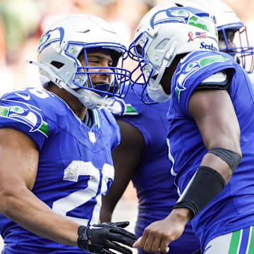 Sep 8, 2024; Seattle, Washington, USA; Seattle Seahawks running back Zach Charbonnet (26) celebrates with quarterback Geno Smith (7) after catching a touchdown pass against the Denver Broncos during the fourth quarter at Lumen Field.