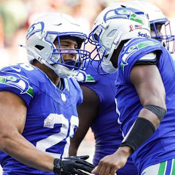 Sep 8, 2024; Seattle, Washington, USA; Seattle Seahawks running back Zach Charbonnet (26) celebrates with quarterback Geno Smith (7) after catching a touchdown pass against the Denver Broncos during the fourth quarter at Lumen Field. Mandatory Credit: Joe Nicholson-Imagn Images