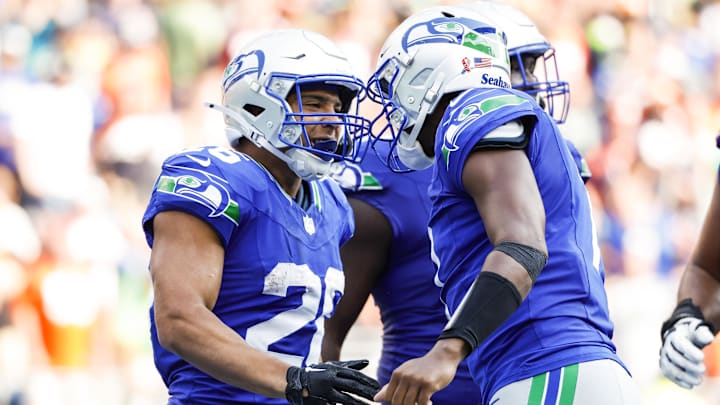 Sep 8, 2024; Seattle, Washington, USA; Seattle Seahawks running back Zach Charbonnet (26) celebrates with quarterback Geno Smith (7) after catching a touchdown pass against the Denver Broncos during the fourth quarter at Lumen Field. Mandatory Credit: Joe Nicholson-Imagn Images