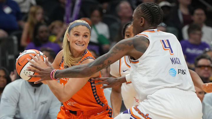 Aug 5, 2025; Phoenix, Arizona, USA; Connecticut Sun guard Jacy Sheldon (4) shields the ball from Phoenix Mercury forward Natasha Mack (4) in the first half at Footprint Center. Mandatory Credit: Rick Scuteri-Imagn Images