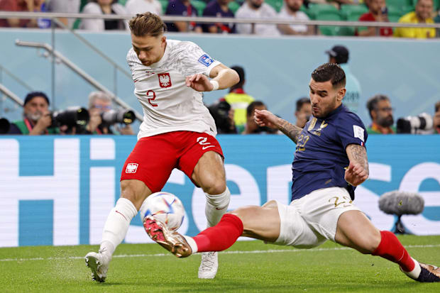 France defender Theo Hernandez blocks a pass by Poland defender Matty Cash.