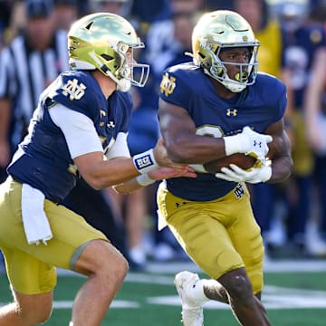 Sep 7, 2024; South Bend, Indiana, USA; Notre Dame Fighting Irish quarterback Riley Leonard (13) hands off to running back Jadarian Price (24) in the third quarter against the Northern Illinois Huskies at Notre Dame Stadium. Mandatory Credit: Matt Cashore-Imagn Images