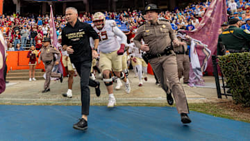 Nov 29, 2025; Gainesville, Florida, USA; Florida State Seminoles head coach Mike Norvell leads his team onto the field before the game against the Florida Gators at Ben Hill Griffin Stadium. Mandatory Credit: Bob Kupbens-Imagn Images