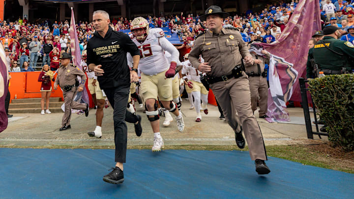 Nov 29, 2025; Gainesville, Florida, USA; Florida State Seminoles head coach Mike Norvell leads his team onto the field before the game against the Florida Gators at Ben Hill Griffin Stadium. Mandatory Credit: Bob Kupbens-Imagn Images