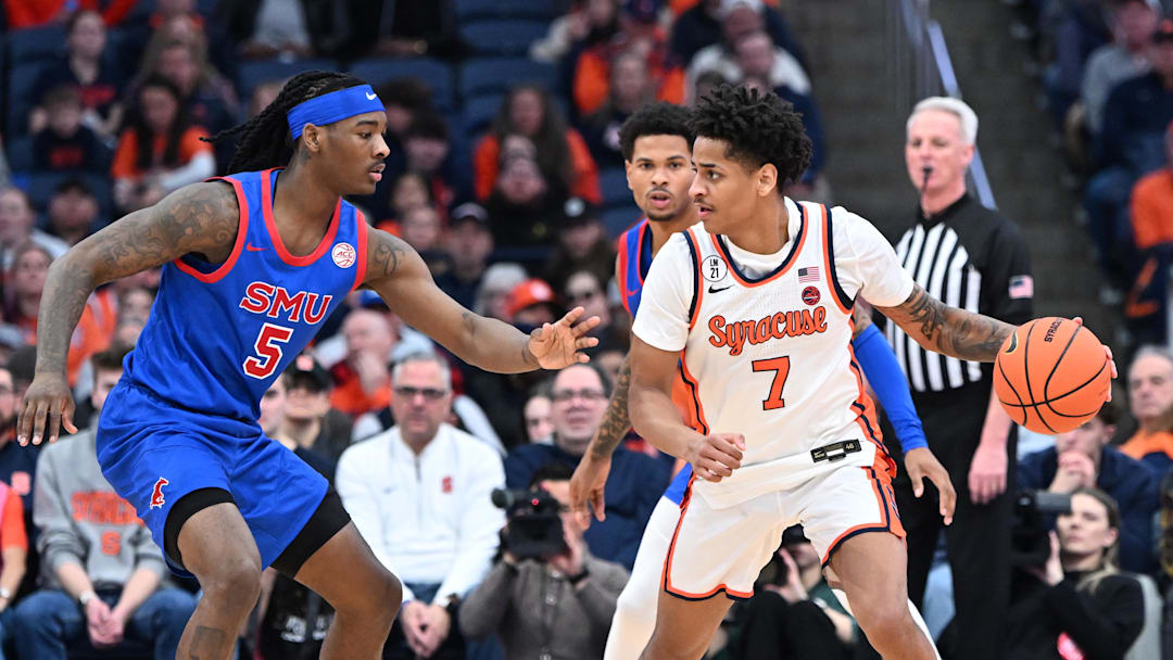 Feb 14, 2026; Syracuse, New York, USA; Syracuse Orange forward Kiyan Anthony (7) looks to get the ball past Southern Methodist University Mustangs guard Jaron Pierre Jr. (5) in the first half at the JMA Wireless Dome. Mandatory Credit: Mark Konezny-Imagn Images