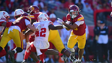 Nov 16, 2024; Los Angeles, California, USA; Southern California Trojans running back Quinten Joyner (0) runs the ball against Nebraska Cornhuskers linebacker Mikai Gbayor (42) during the first half at the Los Angeles Memorial Coliseum. Mandatory Credit: Gary A. Vasquez-Imagn Images