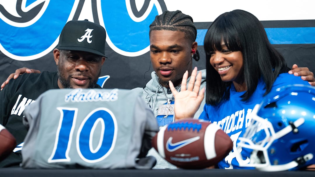 Kenny Adams sits next to Andre Adams and Sheena Adams during a ceremony announcing Andre AdamÕs commitment to the University of Colorado at Antioch High School on Tuesday, April, 14, 2026 in Antioch.
