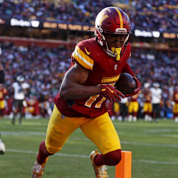 Dec 22, 2024; Landover, Maryland, USA; Washington Commanders wide receiver Terry McLaurin (17) catches a touchdown  pass against Philadelphia Eagles cornerback Quinyon Mitchell (27) during the second quarter at Northwest Stadium. Mandatory Credit: Peter Casey-Imagn Images
