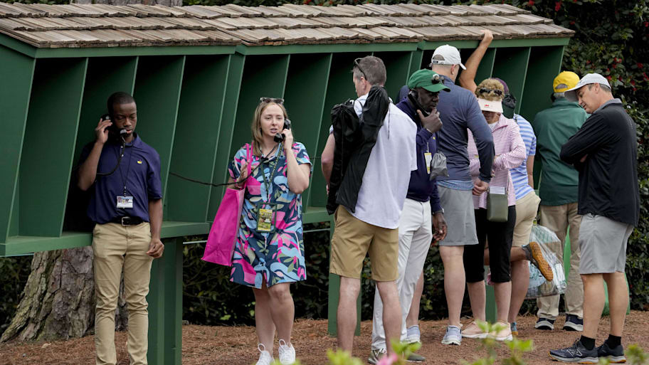 Patrons use course phones by the no. 8 tee box during a practice round for the Masters Tournament.
