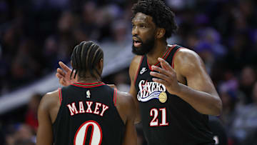Dec 7, 2025; Philadelphia, Pennsylvania, USA; Philadelphia 76ers center Joel Embiid (21) talks with guard Tyrese Maxey during the second quarter against the Los Angeles Lakers at Xfinity Mobile Arena. Mandatory Credit: Bill Streicher-Imagn Images