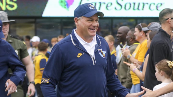 Sep 27, 2025; Morgantown, West Virginia, USA; West Virginia Mountaineers head coach Rich Rodriguez walks on the field and greets fans before their game against the Utah Utes at Milan Puskar Stadium. Mandatory Credit: Ben Queen-Imagn Images