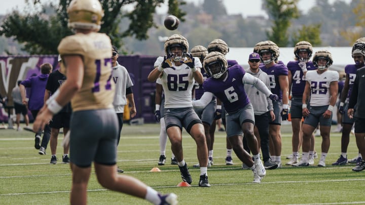 Keleki Latu (85) catches a ball in front of linebacker Bryun Parham.