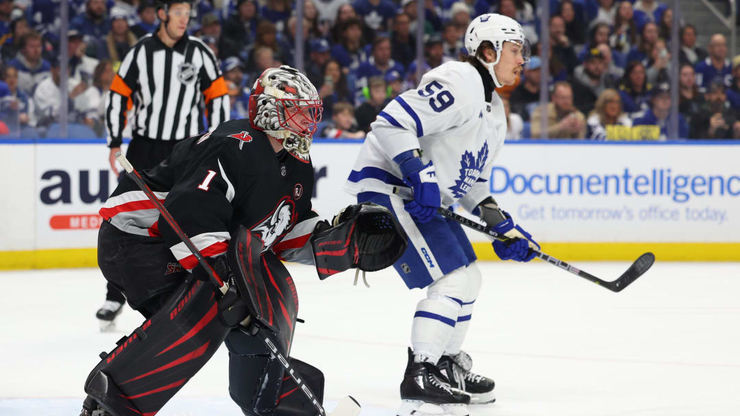 Mar 30, 2024; Buffalo, New York, USA;  Buffalo Sabres goaltender Ukko-Pekka Luukkonen (1) and Toronto Maple Leafs left wing Tyler Bertuzzi (59) look for the puck during the first period at KeyBank Center. Mandatory Credit: Timothy T. Ludwig-USA TODAY Sports