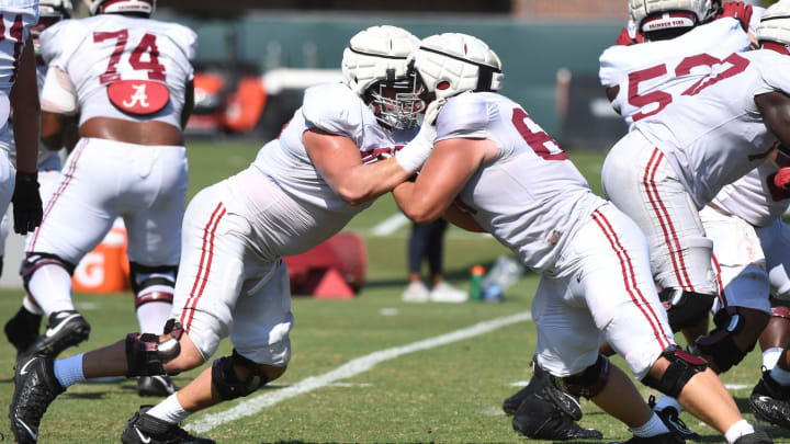 The Crimson Tide players and coaches continue working toward the season opener in practice Tuesday, Aug. 13, 2024. Alabama offensive lineman Wilkin Formby (75), left, blocks a teammate.