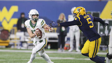 Nov 16, 2024; Morgantown, West Virginia, USA; Baylor Bears quarterback Sawyer Robertson (13) escapes from West Virginia Mountaineers defensive lineman Sean Martin (5) during the fourth quarter at Mountaineer Field at Milan Puskar Stadium. Mandatory Credit: Ben Queen-Imagn Images