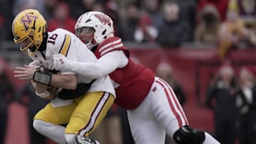 Nov 29, 2024; Madison, Wisconsin, USA; Wisconsin defensive lineman Elijah Hills (94) sacks Minnesota quarterback Max Brosmer (16) during the second quarter of their game at Camp Randall Stadium. Mandatory Credit: Mark Hoffman/USA TODAY Network via Imagn Images