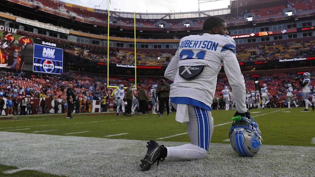 Nov 9, 2025; Landover, Maryland, USA; Detroit Lions cornerback Amik Robertson (21) kneels on the field during warmups prior to a game against the Washington Commanders at Northwest Stadium. Mandatory Credit: Peter Casey-Imagn Images