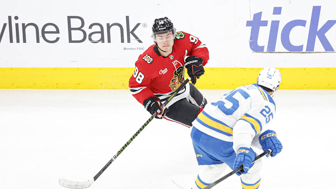 Apr 11, 2026; Chicago, Illinois, USA; Chicago Blackhawks center Connor Bedard (98) looks to pass the puck against St. Louis Blues right wing Jordan Kyrou (25) during the second period at United Center. Mandatory Credit: Kamil Krzaczynski-Imagn Images